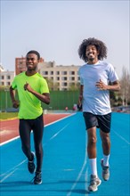 Vertical photo of two african american young ans sportive runners smiling while training together