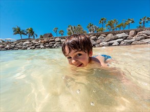 Portrait of a boy on vacation on a beach in the Canary Islands. Concept of happy family outdoors.