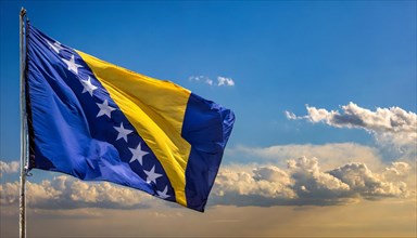The flag of Bosnia and Herzegovina flutters in the wind, isolated against a blue sky