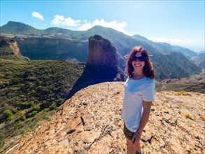 A happy woman at the Roque Palmes viewpoint near Roque Nublo in Gran Canaria, Canary Islands