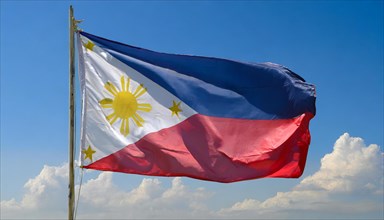 The flag of the Philippines, fluttering in the wind, isolated, against the blue sky