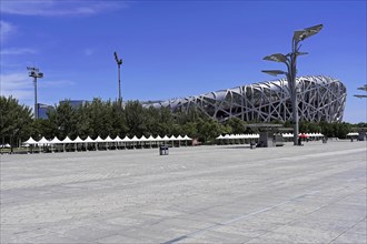 Beijing, China, Asia, Modern stadium complex seen from the spacious, empty forecourt on a sunny