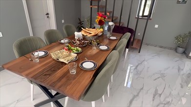 Dining room in a modern house. Dining table, chairs and cutlery
