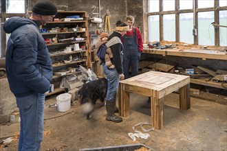 Family inspecting the table built by their son in the workshop, Mecklenburg-Vorpommern, Germany,