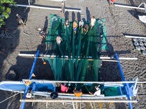 Fishermen unload their catch from their outrigger boat in the morning. Amed, Karangasem, Bali,