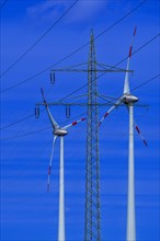 Power pylon with high-voltage lines and wind turbines at the Avacon substation Helmstedt,