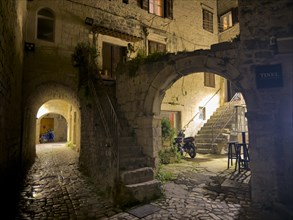 Stone arch and stairs of an old building illuminated at night, Trogir, Dalmatia, Croatia, Europe