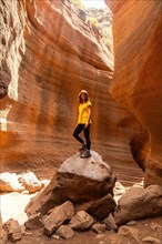 A woman in a yellow t-shirt in the limestone canyon Barranco de las Vacas in Gran Canaria, Canary