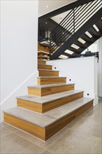 American walnut wood topped with granite and black powder coated cold rolled steel stairs inside a