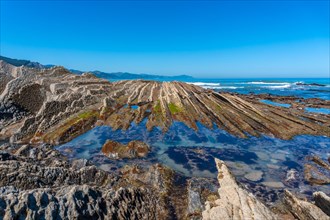 Beautiful landscape of the Flysch Basque Coast geopark in Zumaia with low seas, Gipuzkoa