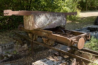 Rusty wagon, wagon on rail with block of Michelnau tuff, red basalt, red lava, slag agglomerate,