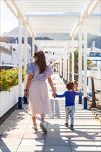 A mother with her son walking on holiday in Puerto de Las Nieves in Agaete on Gran Canaria, Spain,