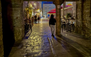 Person walking along a cobblestone street at night, Trogir, Dalmatia, Croatia, Europe