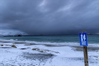 Sign for public toilet on beach, winter, snow, cloudy, Senja, Troms, Norway, Europe