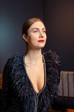 Portrait of gorgeous woman in cocktail dress with feather collar
