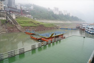 Yichang, Hubei Province, China, Asia, Foggy day with view of ships at a jetty along a river with a