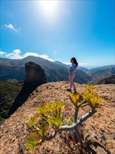 A woman hiker at the Roque Palmes viewpoint near Roque Nublo on Gran Canaria, Canary Islands