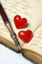 Pen with pen holder and red hearts on diary