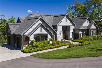Contemporary natural stone and brown stained wood and cedar shingles clad luxurious bungalow style