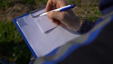 Close up of a female hand writing in a notepad