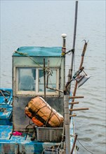 The cluttered cabin and deck of a fishing boat with nets and gear onboard, in South Korea