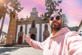 Selfie of a tourist at sunset next to the Basilica of Nuestra Senora del Pino in the municipality