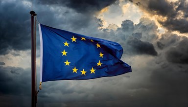 The flag of the EU flutters in the wind, isolated, against dark gloomy clouds