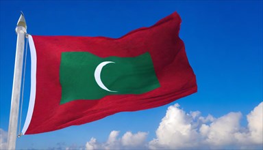 The flag of Maldives, fluttering in the wind, isolated, against the blue sky