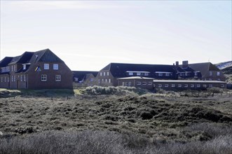 List Youth Hostel, A row of attached brick houses bordering a wild meadow, Sylt, North Frisian