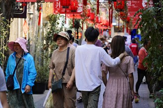 Strolling through the restored Tianzifang neighbourhood, people walking through a shopping street