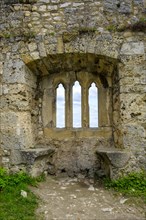 Gothic tracery window in an old fragment of wall, ruins of the medieval Hohenurach Castle, Bad