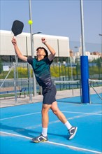 Vertical full length photo of a caucasian young sportive man trying to reach the ball playing
