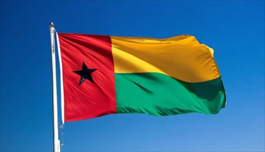 The flag of Guinea-Bissau, fluttering in the wind, isolated, against the blue sky