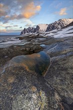 Rocky coast in front of Bergen, sea and pond, morning mood with clouds, winter, Tungeneset, Senja,