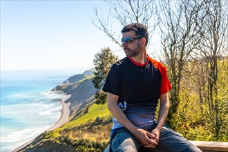 Portrait of a man looking at the beautiful coastal landscape in the flysch of Zumaia, Gipuzkoa.