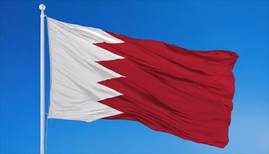 The flag of Bahrain flutters in the wind, isolated against a blue sky