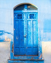 Details of an old blue door. An old blue wooden door of a house