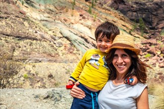 Portrait of mother and son enjoying at the Natural Monument Azulejos de Veneguera or Rainbow Rocks