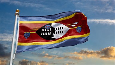 The flag of Swaziland, Kingdom of Eswatini, flutters in the wind, isolated, against the blue sky