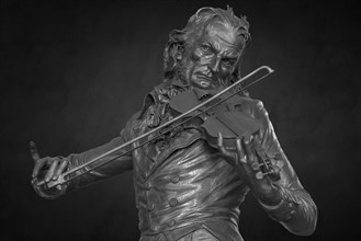 Detailed view on dark background, bronze statue of the violinist Niccolo Paganini by the artist