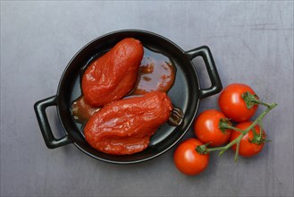 Whole tinned tomatoes in a pot and tomatoes
