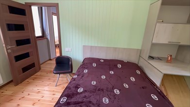 Interior of a bedroom with a bed and a wooden floor
