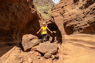 A tourist woman with hat in the limestone canyon Barranco de las Vacas in Gran Canaria, Canary