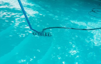 Pool maintenance and cleaning with vacuum hose. Cleaning swimming pool with suction hose