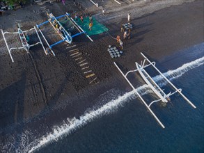 Fishermen unload their catch from their outrigger boat in the morning. Amed, Karangasem, Bali,
