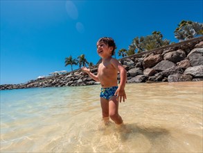 Child on vacation on a beach in the Canary Islands. Concept of happy family outdoors. Family