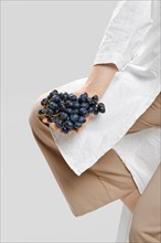 Nutritionist holds a bunch of ripe grapes in her hand