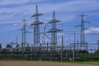 Power pylons with high-voltage lines and wind turbine at the Avacon substation in Helmstedt,
