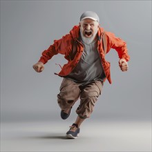 Energetic older man in red jacket runs and shouts against a grey background, run, start,