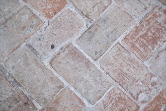 Clay floor tiles arranged in a herringbone pattern